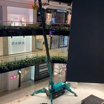 A crane is sitting in the middle of a shopping mall.