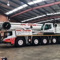 A large crane truck is parked in a warehouse.