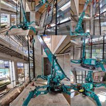 A spider crane is being used in a building under construction.