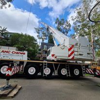 A large crane is parked on the side of a road.