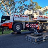 A large crane truck is parked on the side of the road.