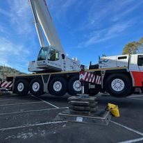 A large crane is parked in a parking lot.