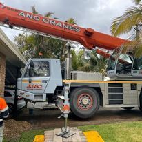 A crane truck is parked in front of a house.