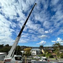 A large crane is sitting on top of a truck in a residential area.
