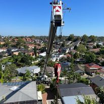A large crane is hanging over a residential area.