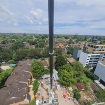 An aerial view of a large crane in the middle of a city.