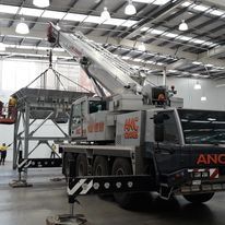 A large crane is parked in a large warehouse.