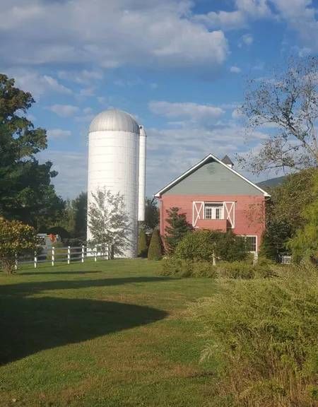 A red barn with a white silo in the background