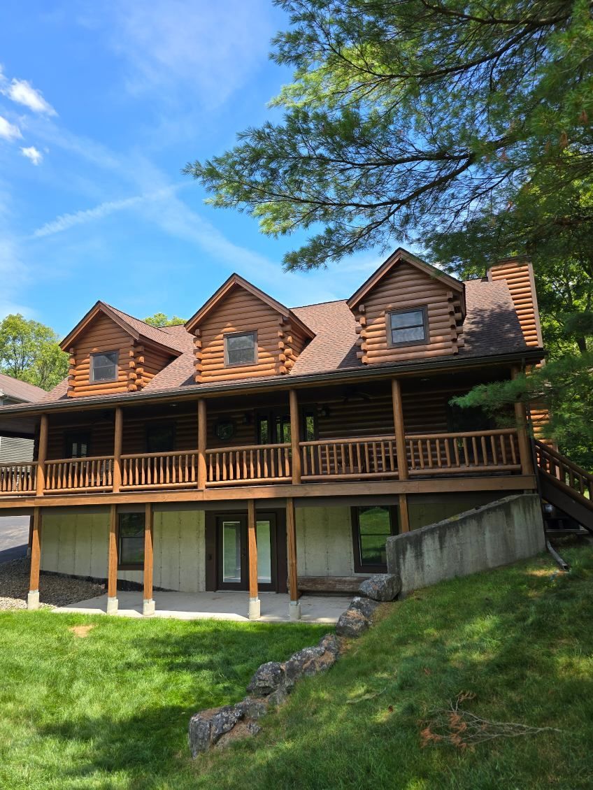 A large wooden deck with a black railing and a canopy.