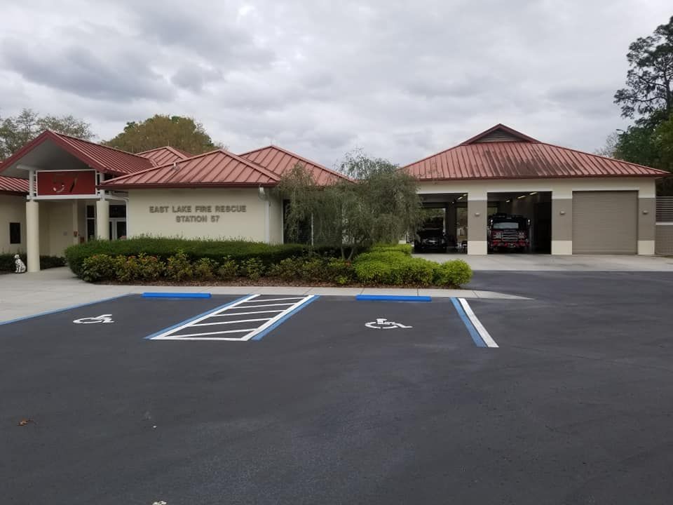 East Lake Fire Rescue Station 57. Building with red tile roof and parking spaces with handicap markings. Cloudy sky.