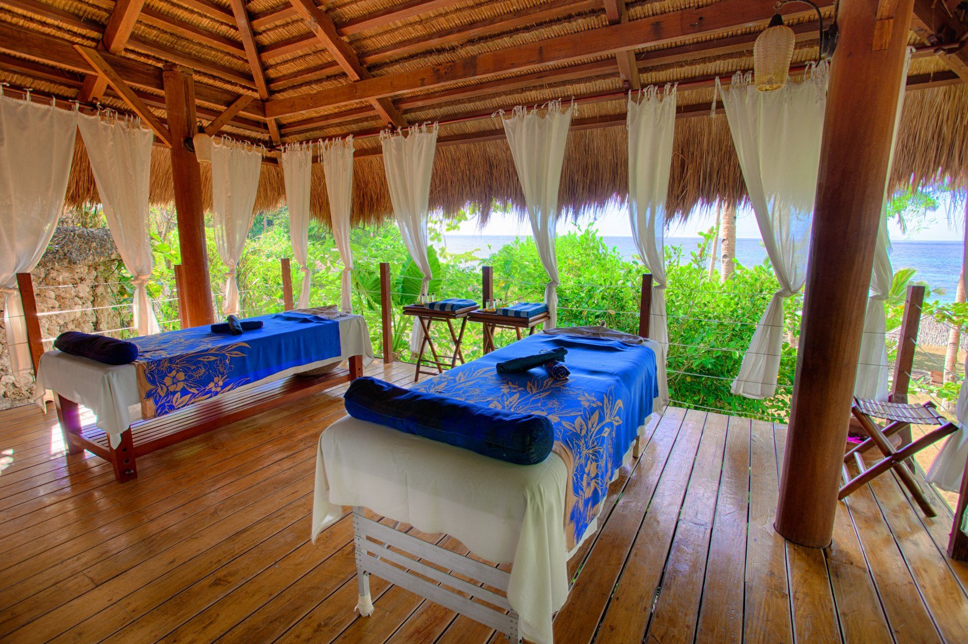 Amun Ini exclusive open-air spa with massage beds and tropical views.