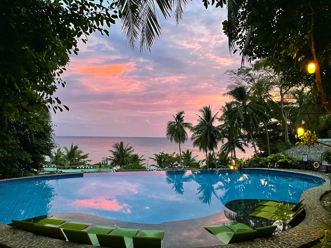 Amun Ini infinity pool overlooking the ocean at sunset.