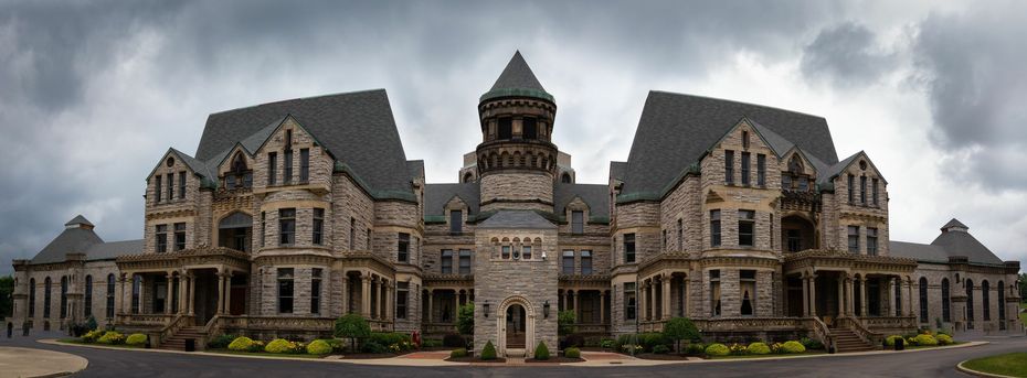 A large stone building with a cloudy sky in the background