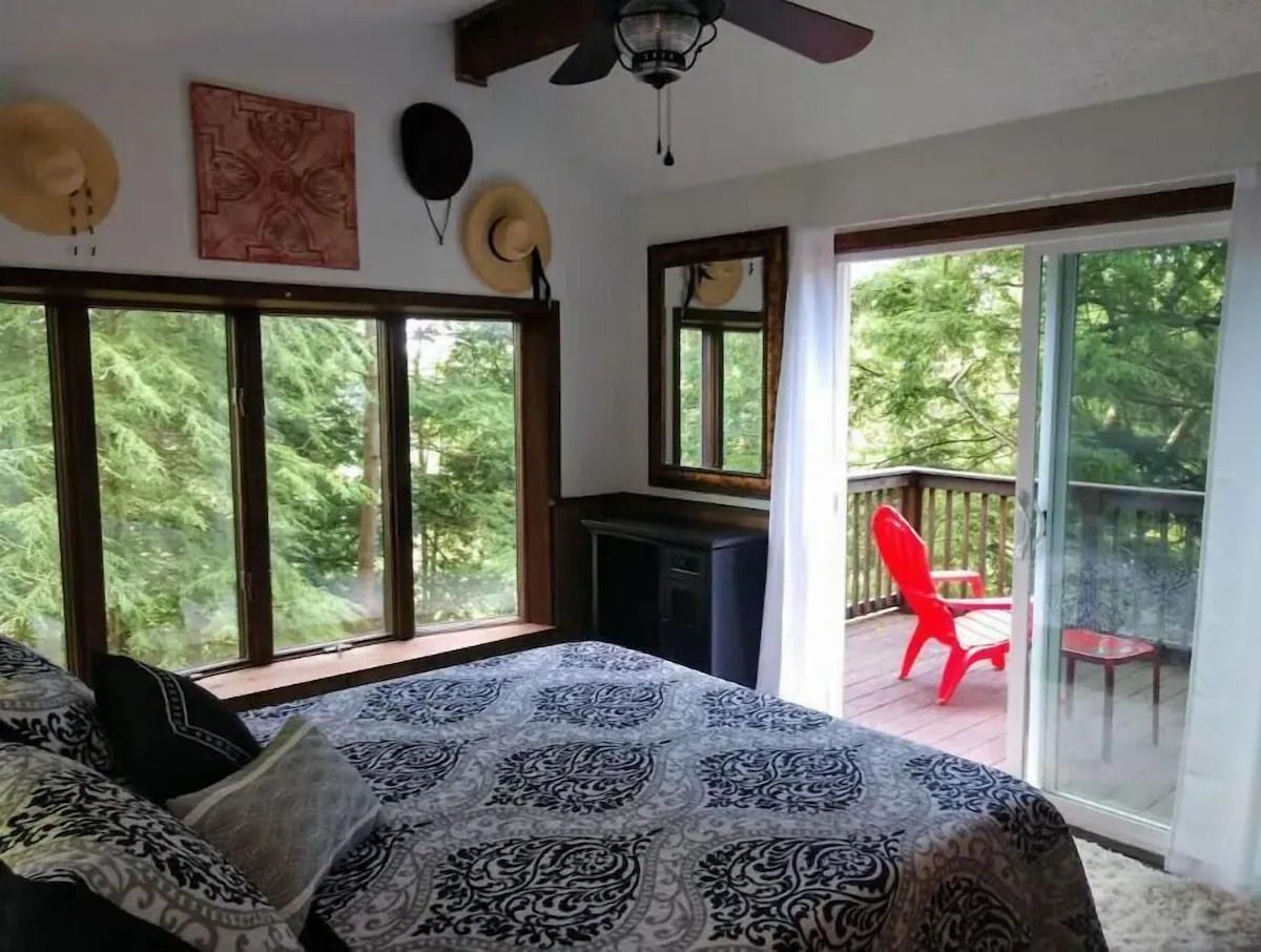 A bedroom with a bed and a ceiling fan