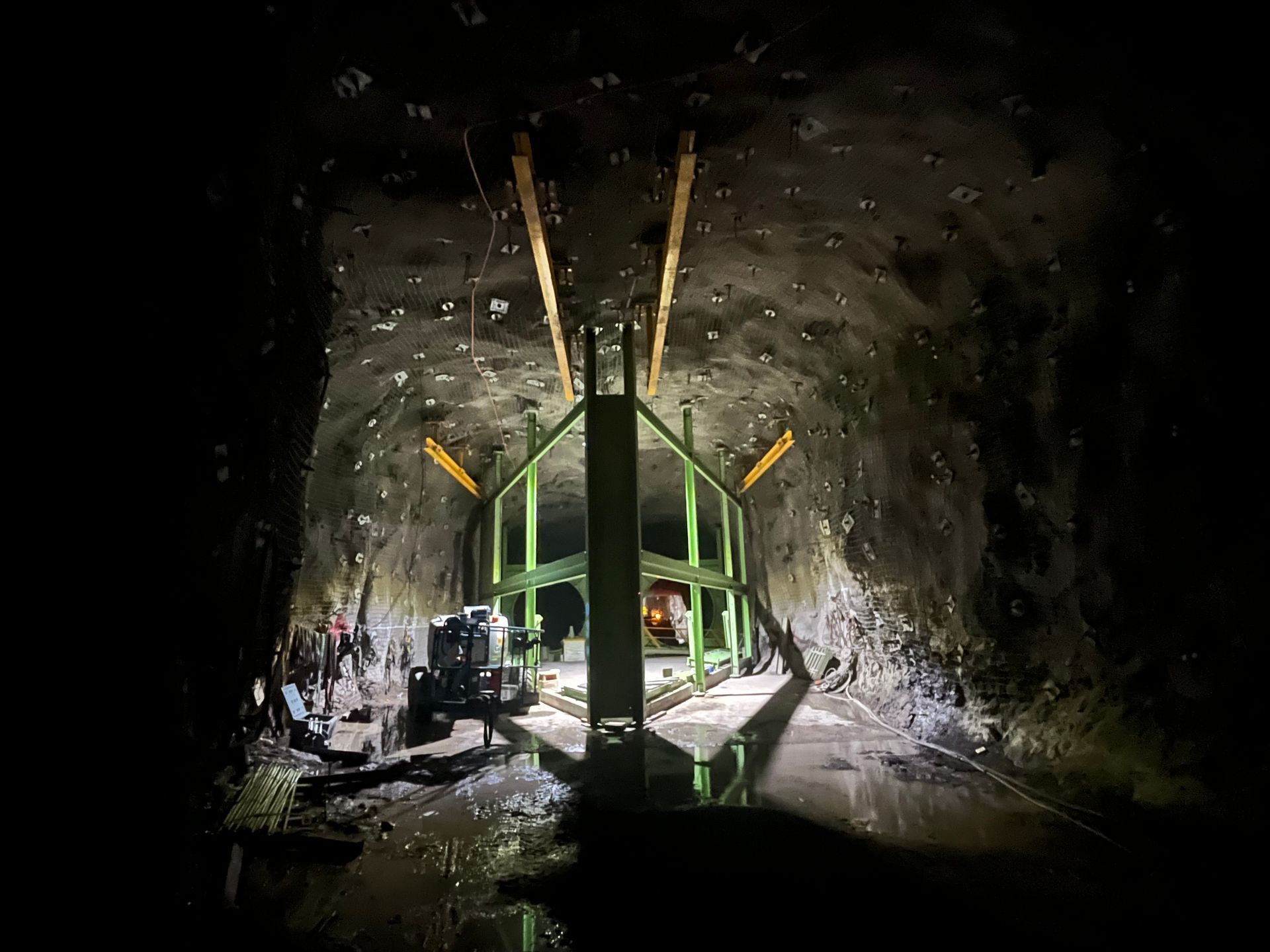 Construction Machinery in a Dark Tunnel Around a Large Green Metal Structure — Vent Doors Australia in Bohle, QLD