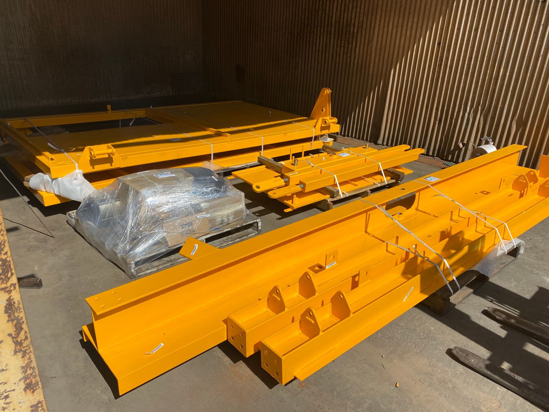 Bright Orange Steel Beams and Machinery Parts Stacked in a Warehouse-like Container — Vent Doors Australia in Bohle, QLD