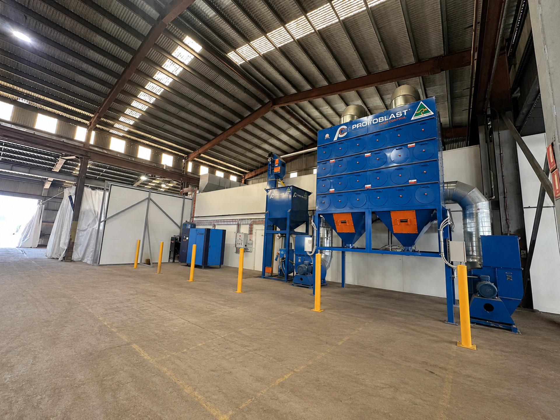 Industrial Warehouse With a Large Blue Processing Machine and Metal Roof Interior — Vent Doors Australia in Bohle, QLD