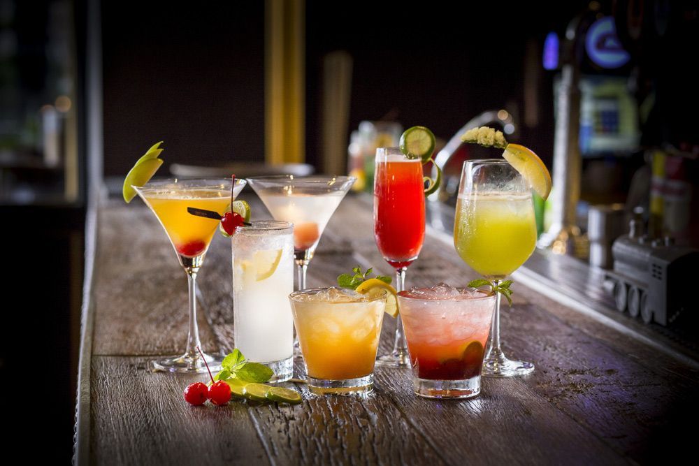 A Variety Of Cocktails Are Sitting On A Wooden Bar — Pacific Palms Bowling Club In Smiths Lake, NSW