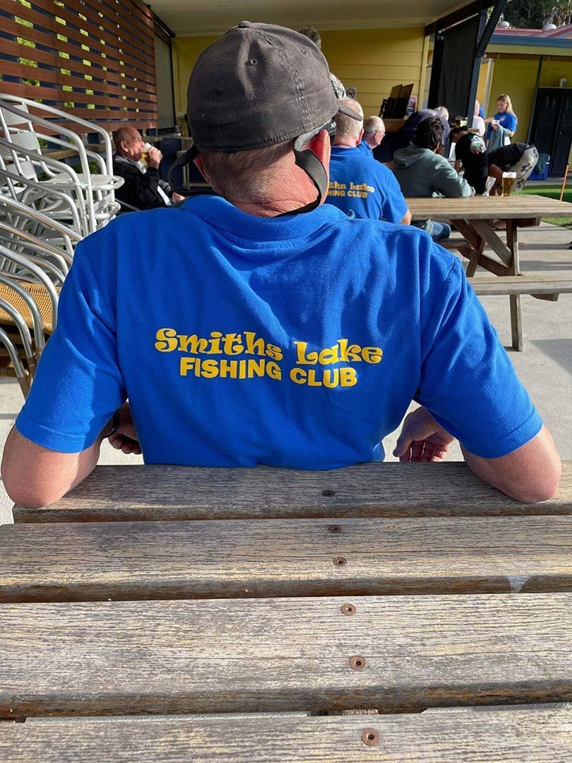 A Man Wearing A Blue Shirt That Says Smith 's Lakes Fishing Club  — Pacific Palms Bowling Club In Smiths Lake, NSW