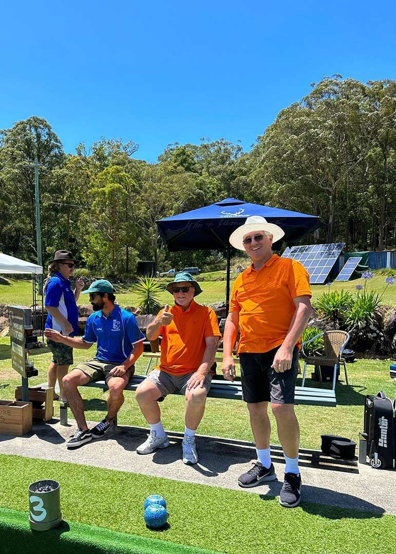 A Group Of Men Are Sitting On A Bench In A Park — Pacific Palms Bowling Club In Smiths Lake, NSW