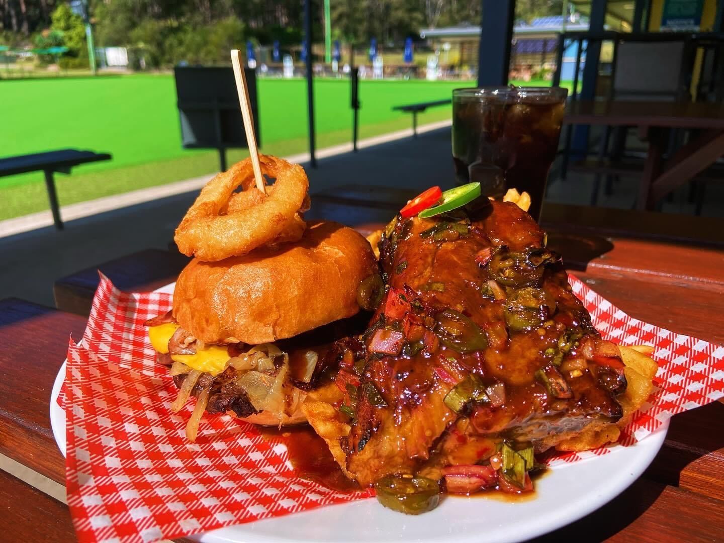 A Plate Of Fried Calamari Rings With French Fries And A Salad On A Wooden Table — Pacific Palms Bowling Club In Smiths Lake, NSW
