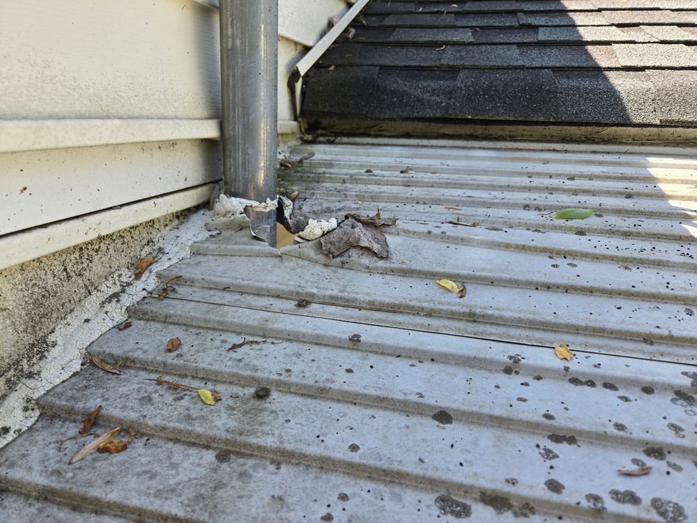 Metal roof with gutter, siding. Debris visible on the roof surface.