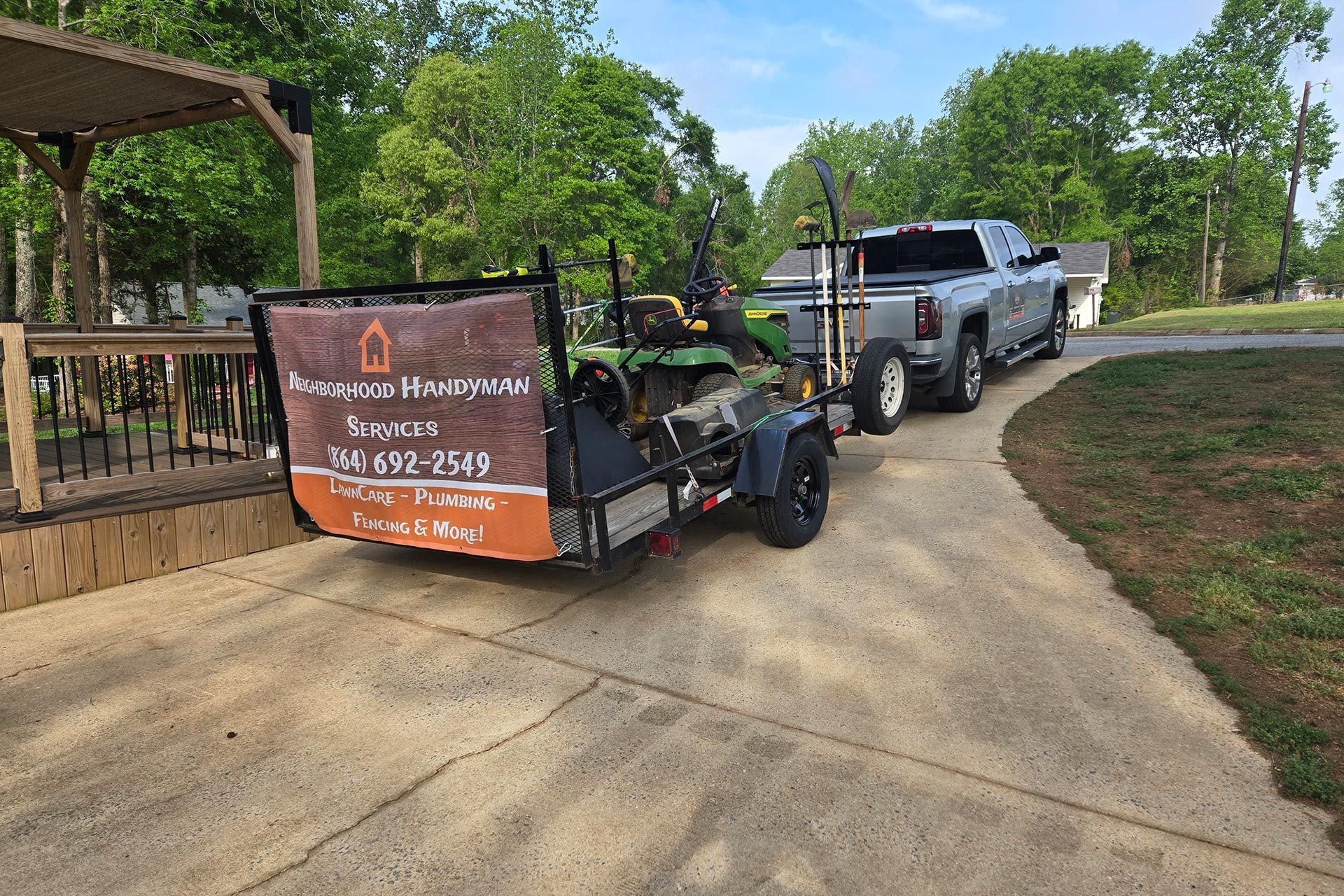 A pickup truck towing a trailer with a lawnmower.  Sign on trailer: 