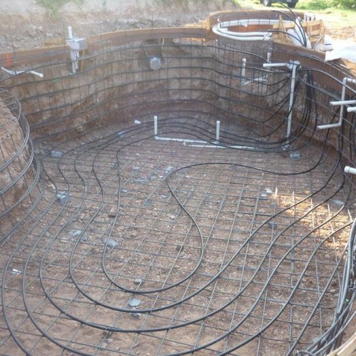 A swimming pool is being built with a lot of wires coming out of it