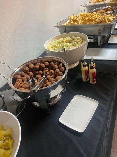 A buffet table with bowls of food and condiments on it.