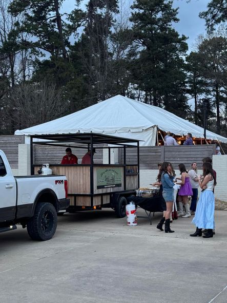 A group of people are standing in a parking lot next to a truck.