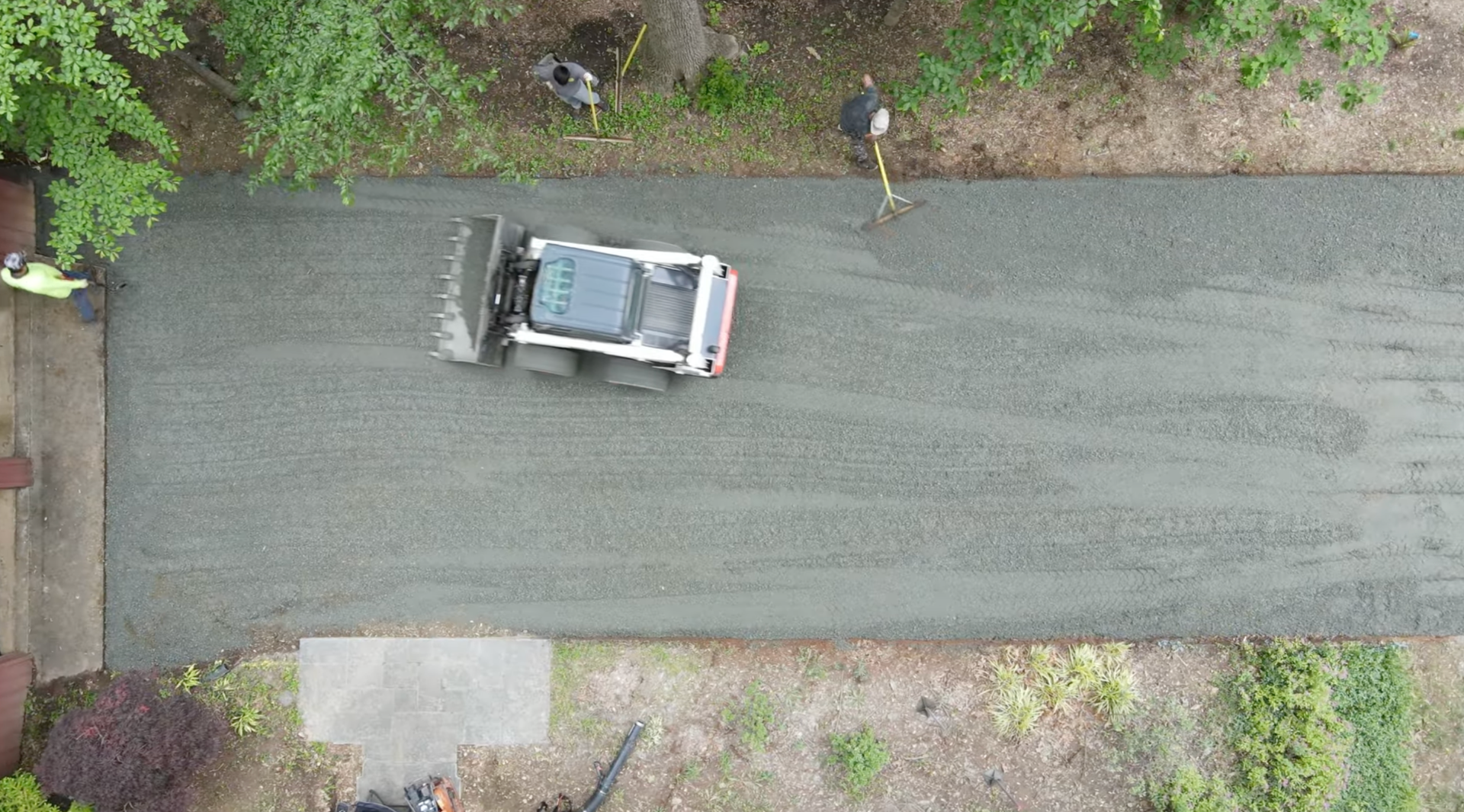 Overhead view of a paving machine spreading asphalt evenly across a roadway while workers guide the process during an asphalt paving service in Highlands Ranch, CO