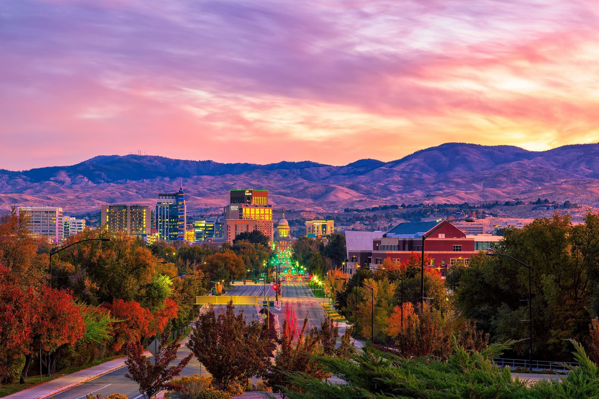 Boise, Idaho skyline at sunset with colorful sky and mountains in the background.