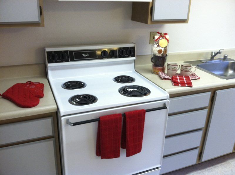 White electric range in a kitchen with red accents.