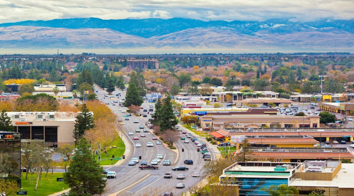 Desert landscape with saguaro cactus, mountains, and colorful sunset.