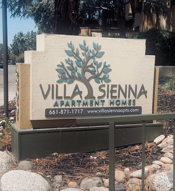 Sign for Villa Sienna Apartment Homes with logo of tree and leaves.