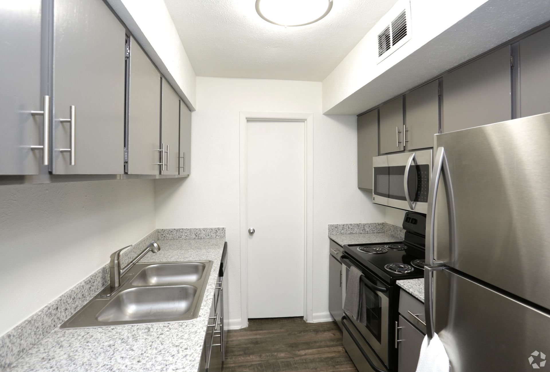 Gray kitchen with stainless steel appliances, cabinets, and a granite countertop.