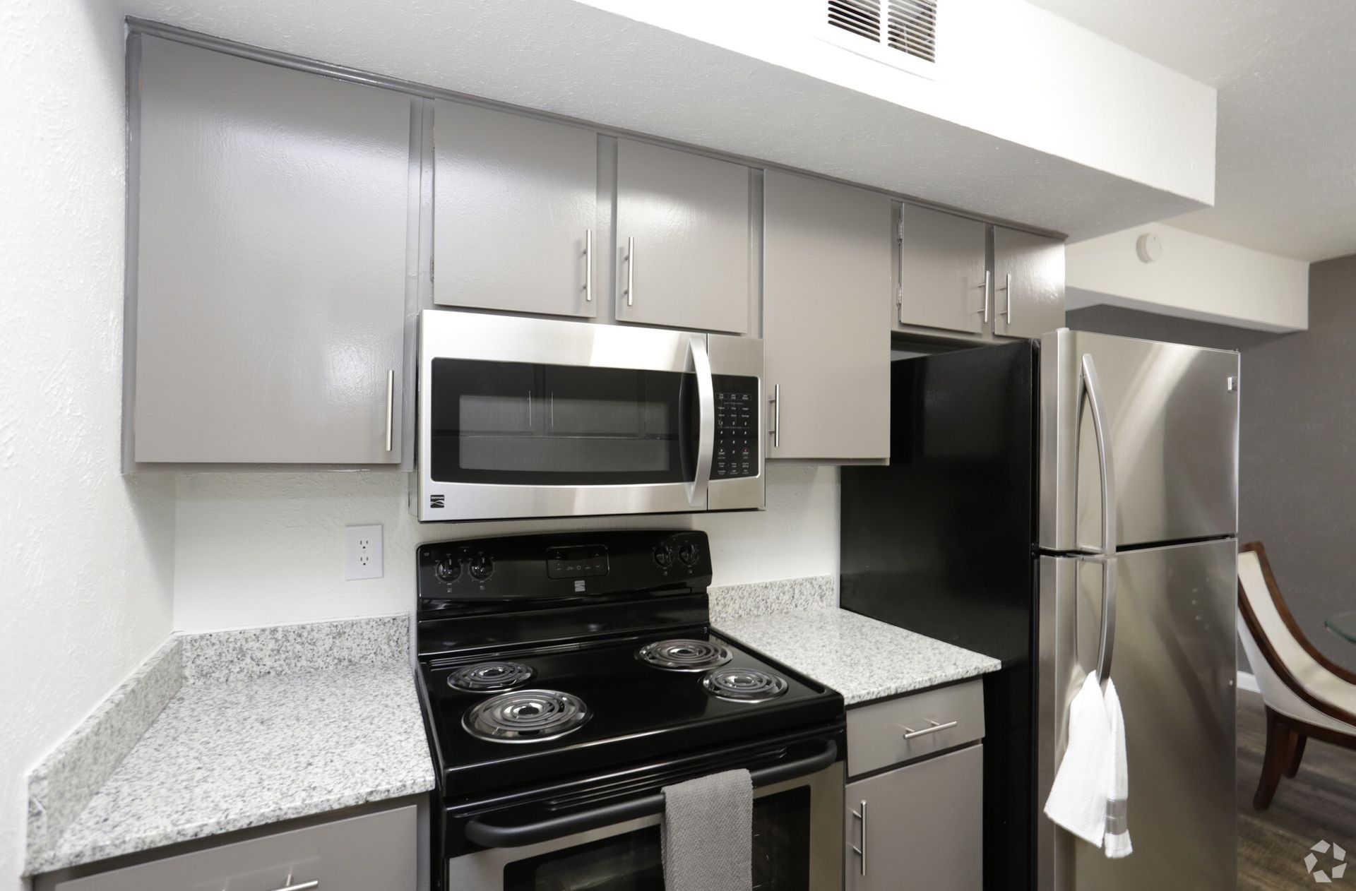 Kitchen with grey cabinets, stainless steel appliances, and granite countertops.