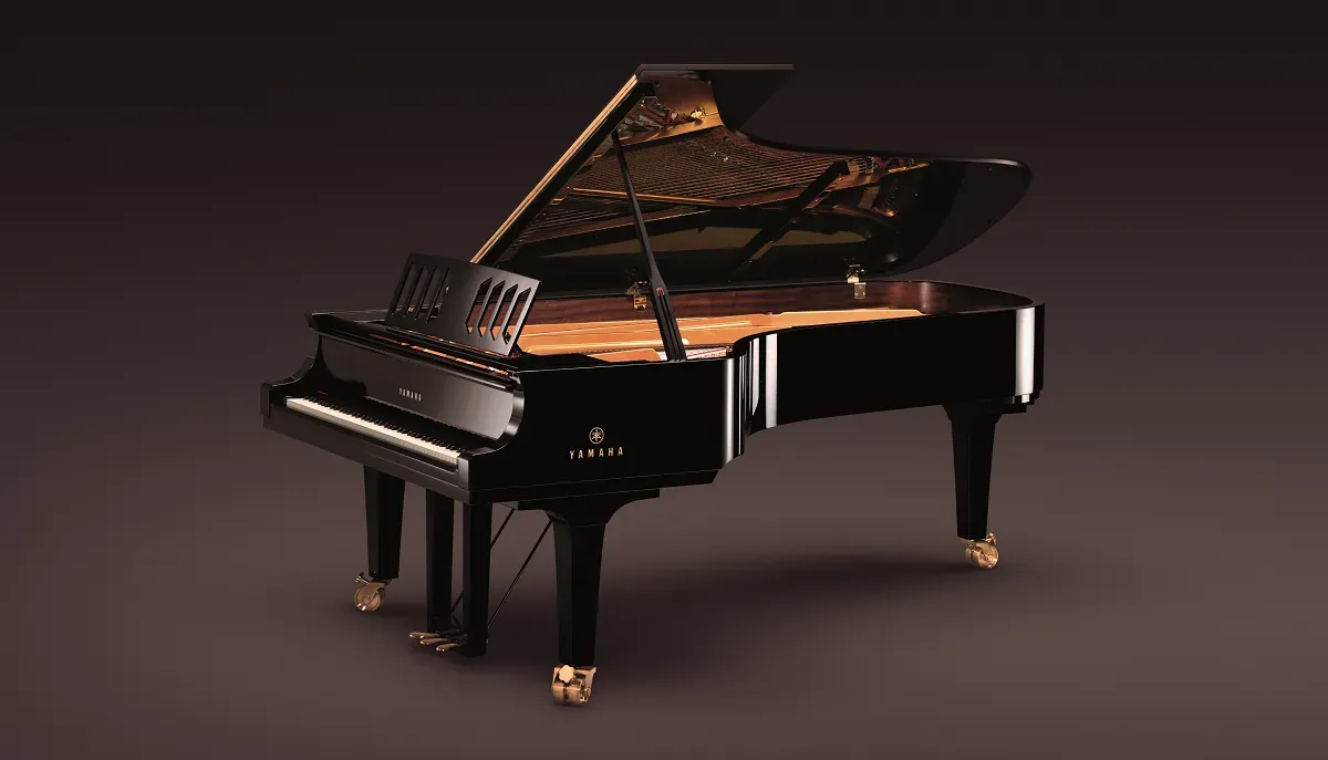 A black grand piano with the lid open on a dark background