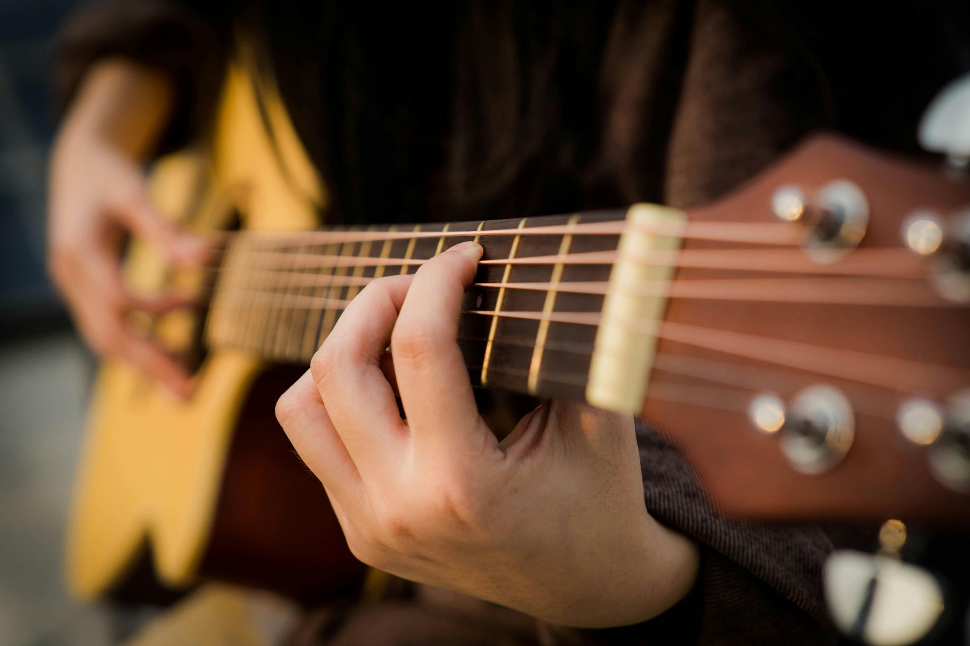 A close up of a person playing an acoustic guitar