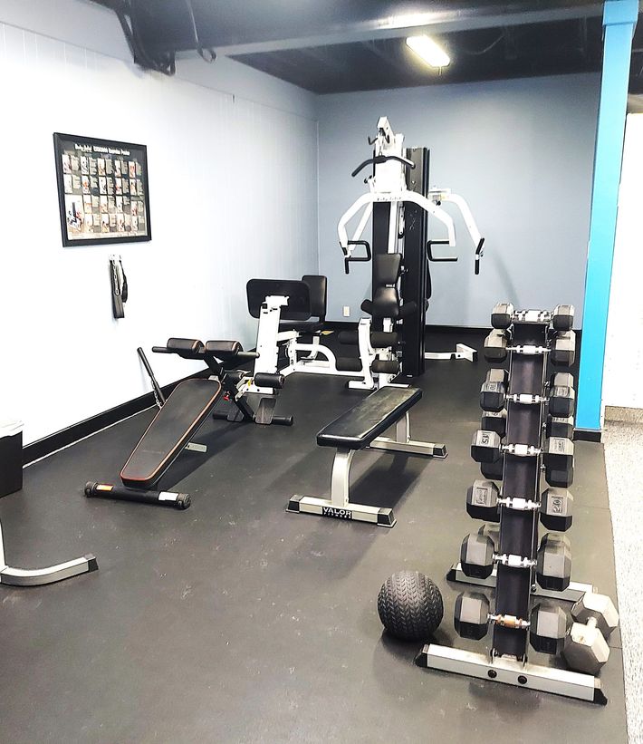 A gym with a bunch of dumbbells and a bench