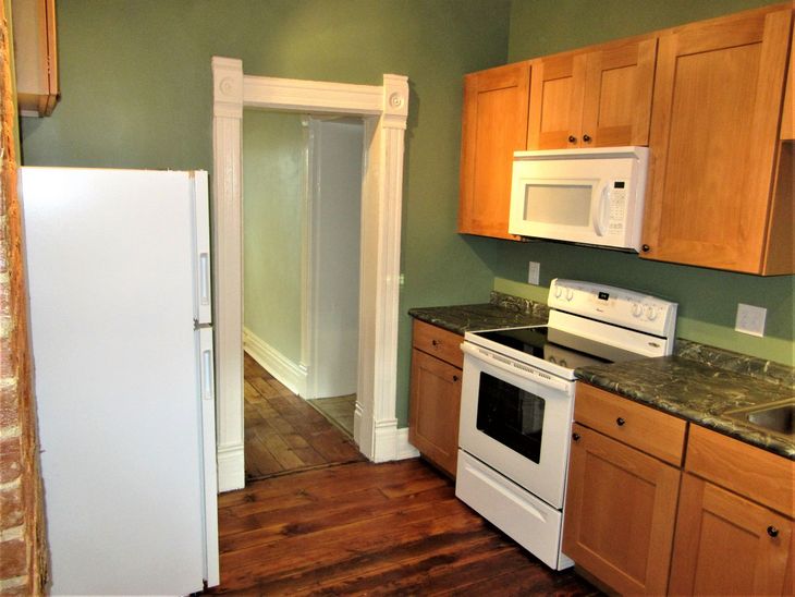 A kitchen with wooden cabinets and a white refrigerator