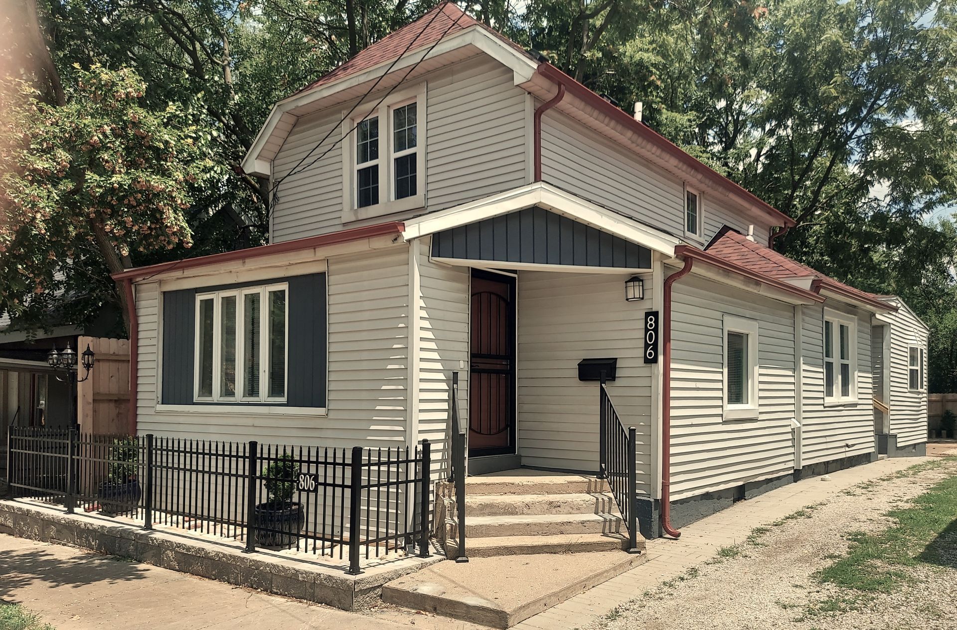 A white house with a red roof and black shutters