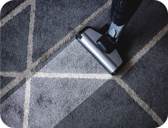 A person is using a vacuum cleaner to clean a carpet.