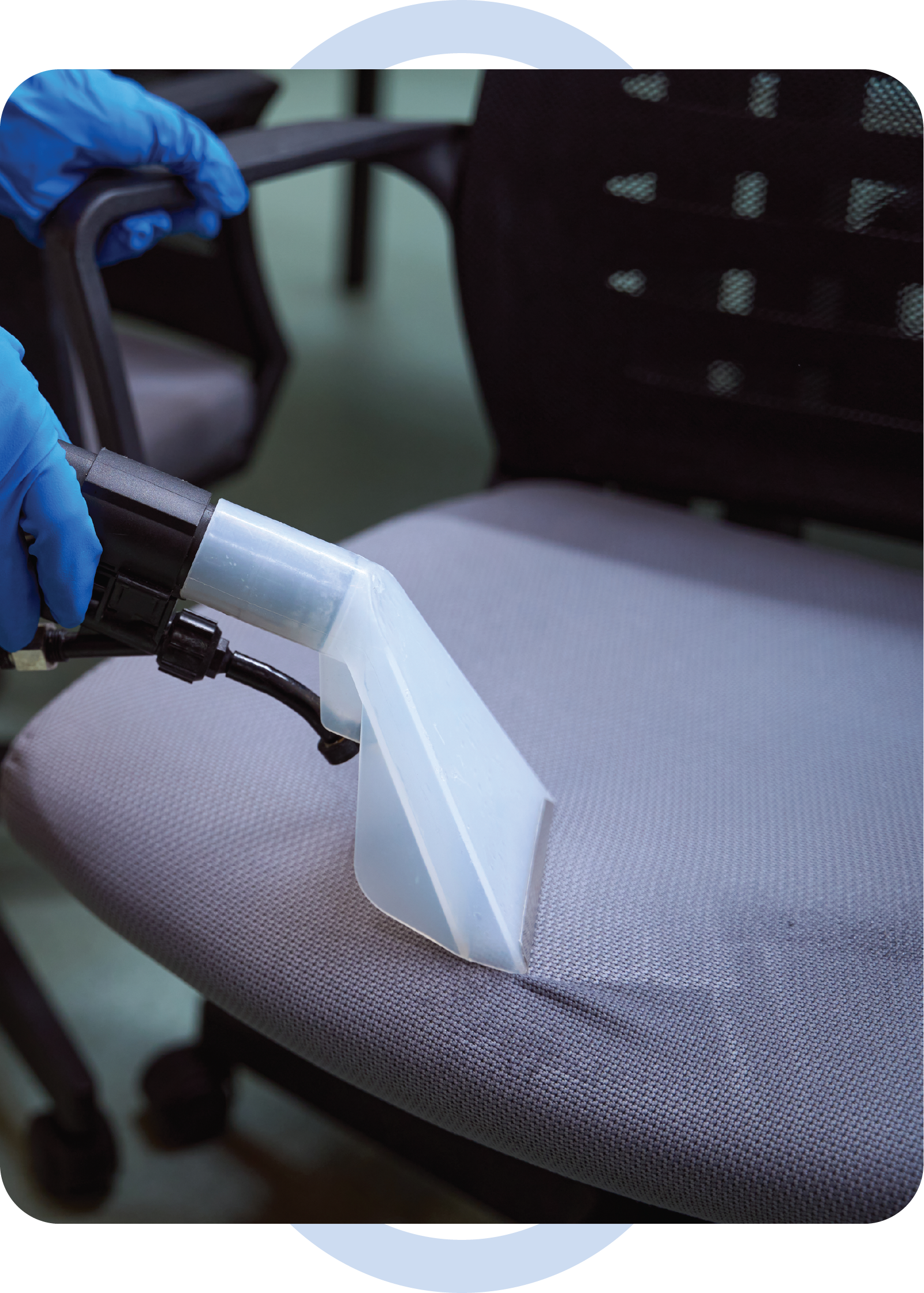 A person is cleaning a chair with a vacuum cleaner.