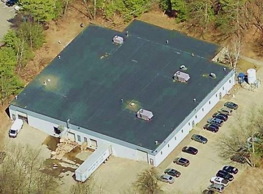 Multi-story brick building with many windows, flagpole, and light fixtures.