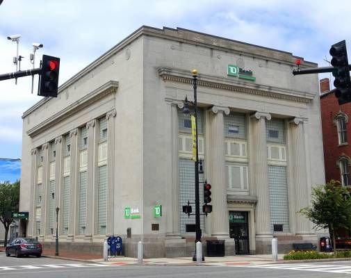 TD Bank building with columns on a city street, traffic lights overhead.