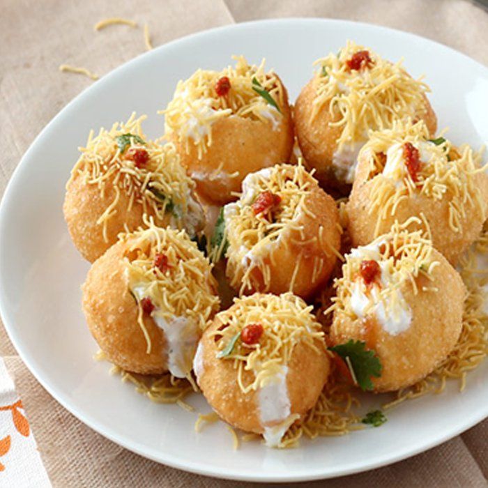 A white plate topped with fried food with cheese on top