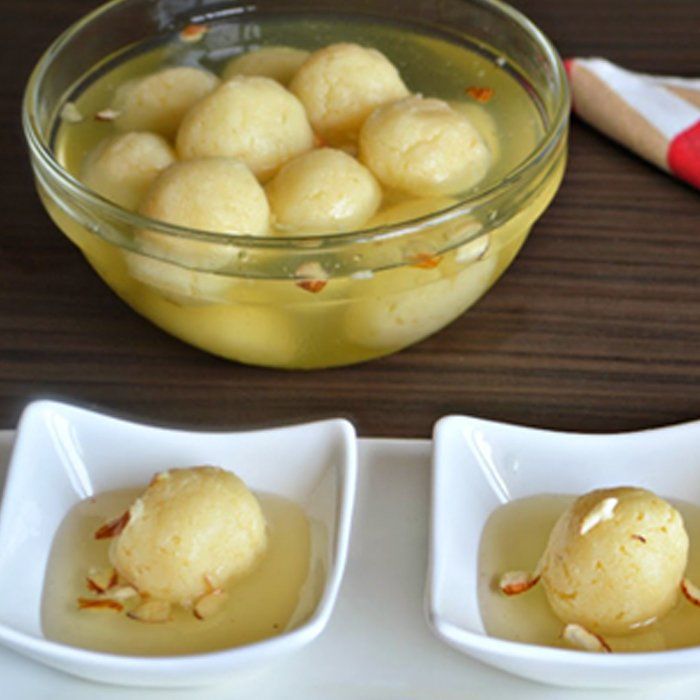 A bowl of food sits on a table next to two small bowls of food
