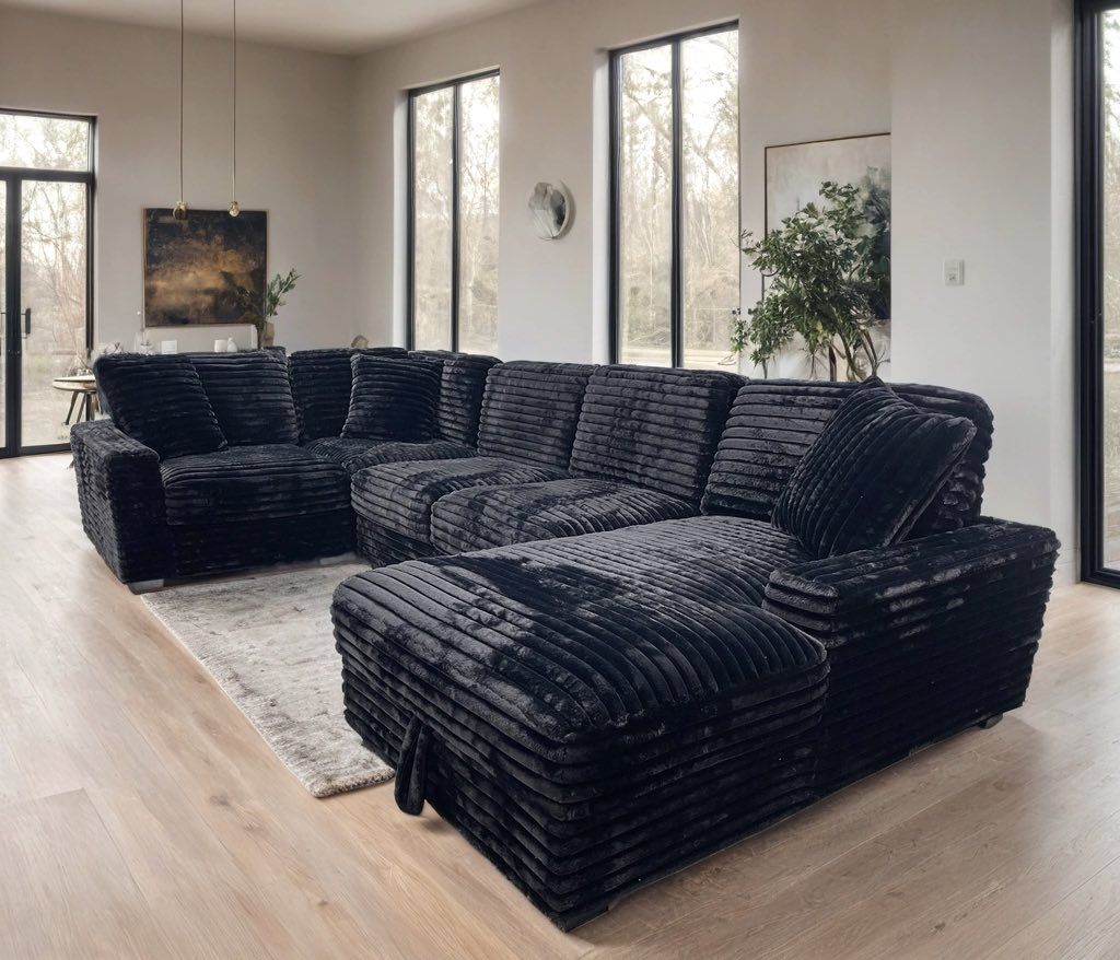 Black corduroy sectional sofa in a bright living room. Bayou furniture New Orleans