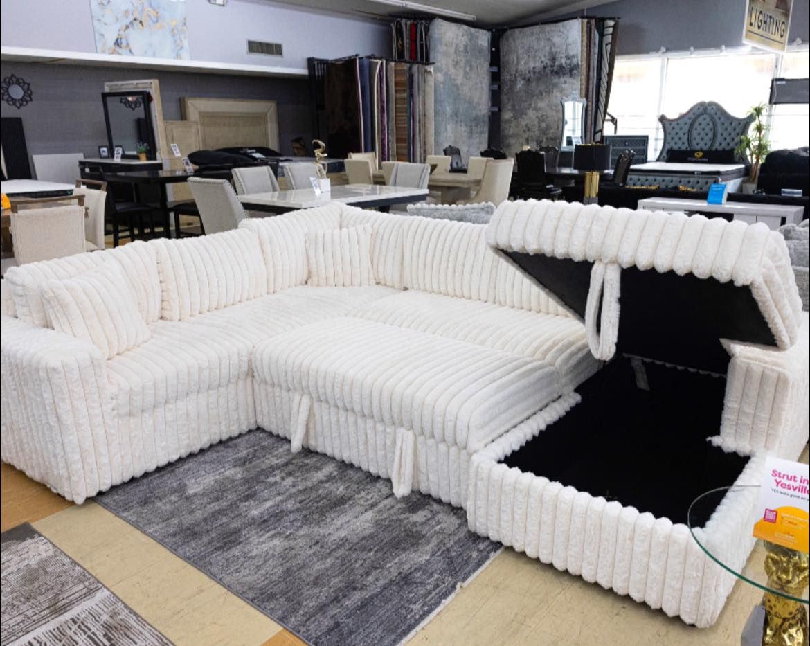 White corduroy sectional sofa with open storage in a furniture store. Bayou furniture New Orleans